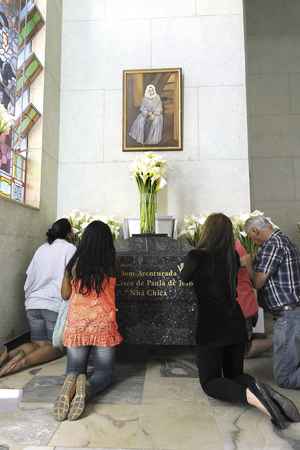 Devotos oram sob monumento que guarda os restos mortais de Nh Chica: pedidos de ajuda e agradecimento por graas alcanadas(foto: Glucia Rodrigues)