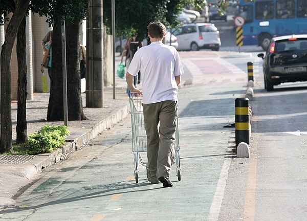 Homem ignora sinalizao e empurra um carrinho de compras em plena ciclovia da rua Professor Morais(foto: Leo Arajo/Encontro)