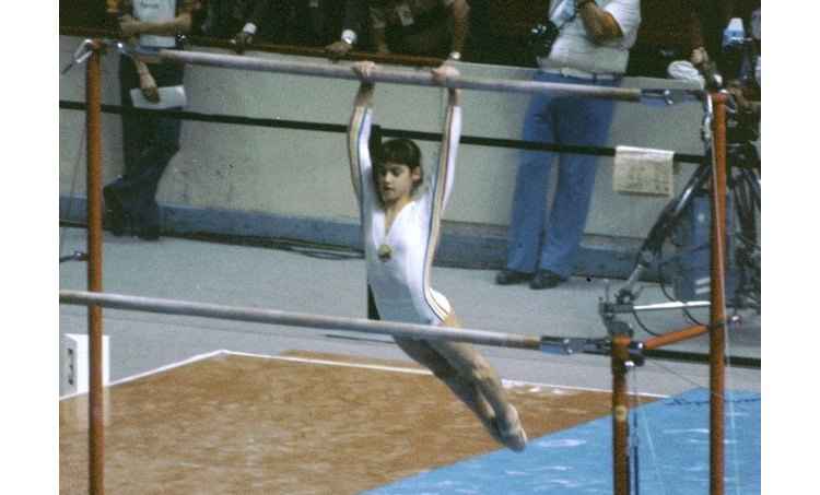 Com apenas 14 anos, a ginasta Nadia Comaneci deixa o pública maravilhado em Montreal ao levar nota máxima nas barras paralelas assimétricas(foto: YouTube/Reprodução) Com apenas 14 anos, a ginasta Nadia Comaneci deixa o pública maravilhado em Montreal ao levar nota máxima nas barras paralelas assimétricas(foto: YouTube/Reprodução)